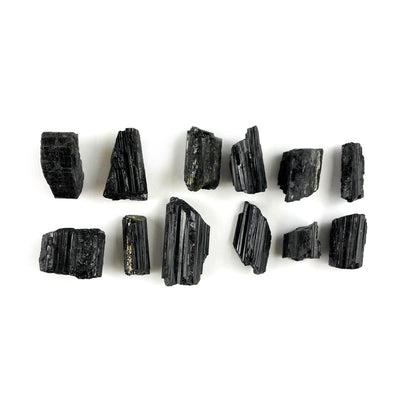 black tourmaline pieces laid out on the table showing varying lengths and widths for this listing