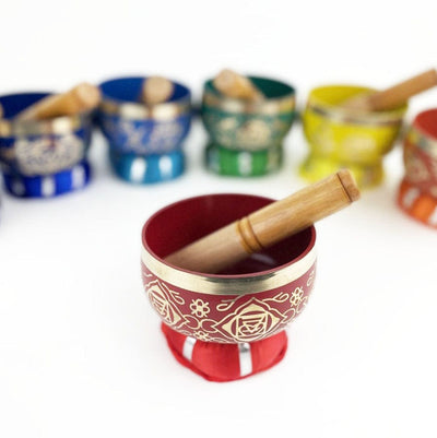 7 Chakra Colorful Singing Bowls, Pillows and Mallets close up on red singing bowl