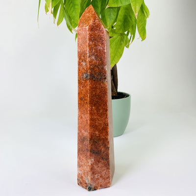 Side view shot of orchid calcite tower point, This picture is also showing the natural inclusions of orchid calcite point. The item is also being displayed on a white back ground.