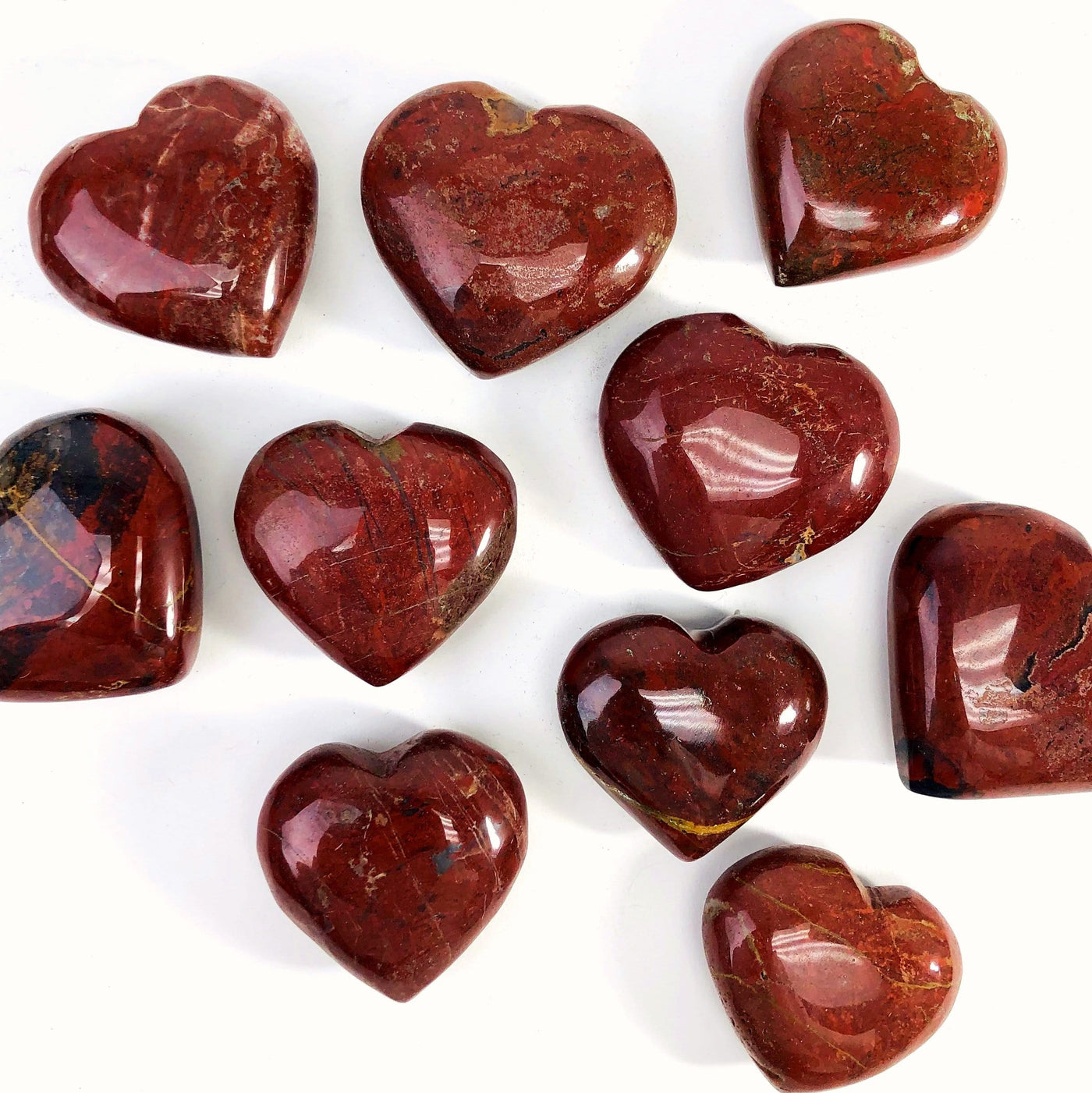 Red Jasper Heart Shaped Stones scattered on white background