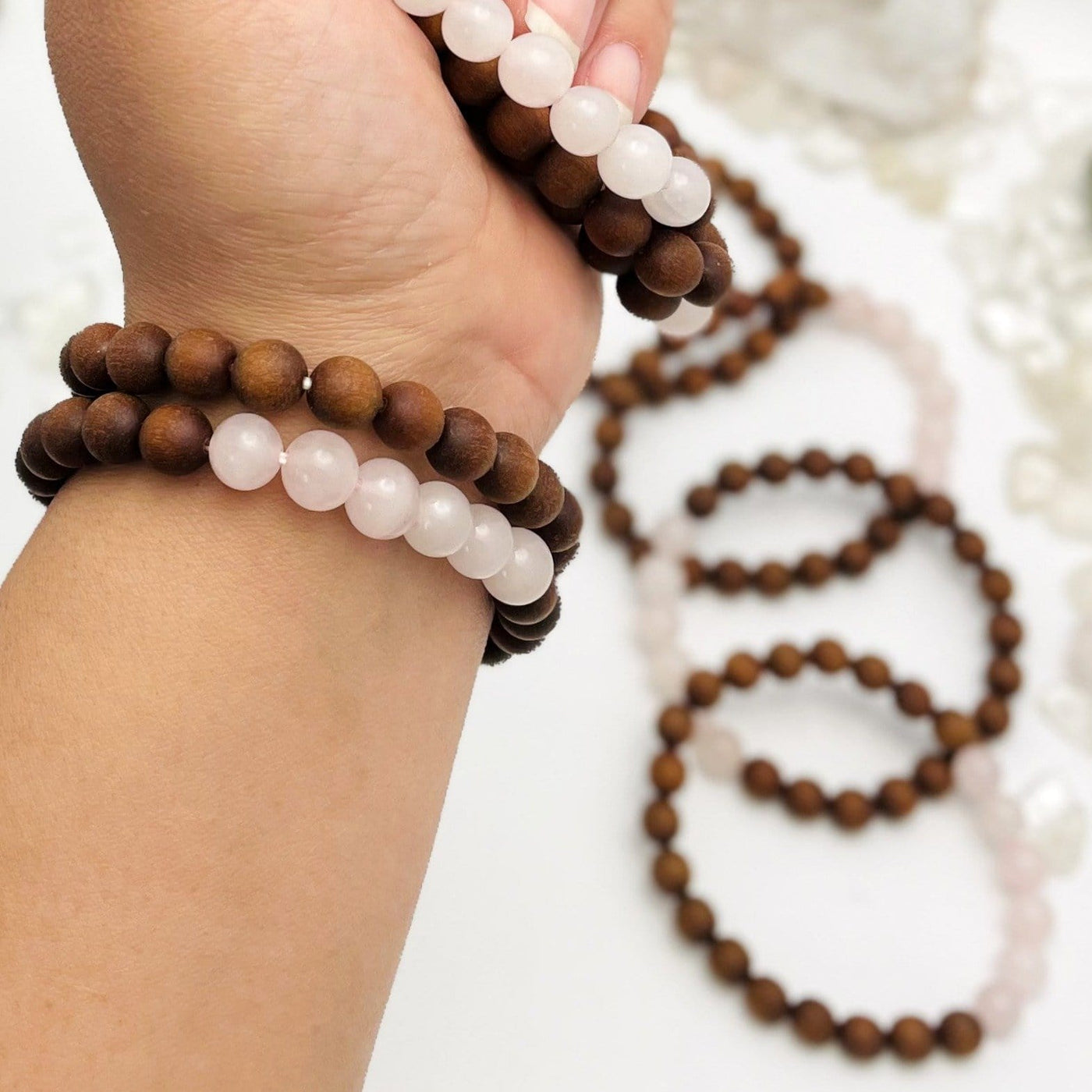 sandalwood bead bracelets with rose quartz in wrist and in hand for size reference