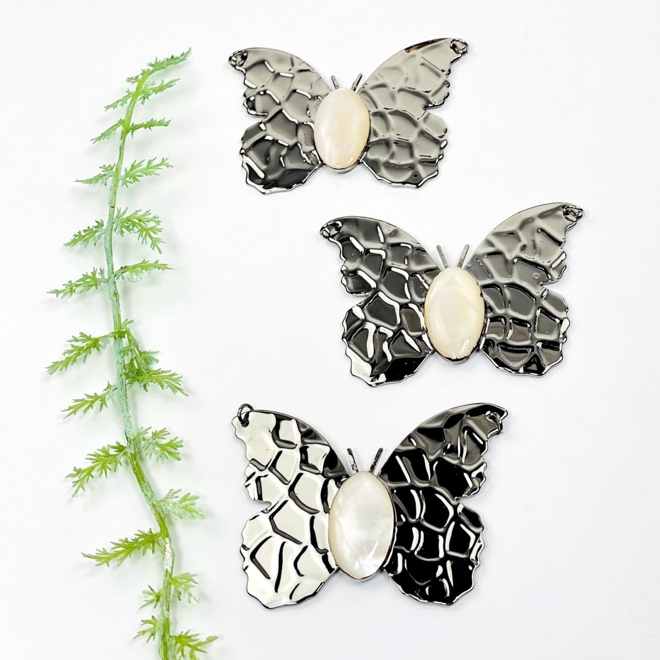 gunmetal butterfly pendants with a mother of pearl center 