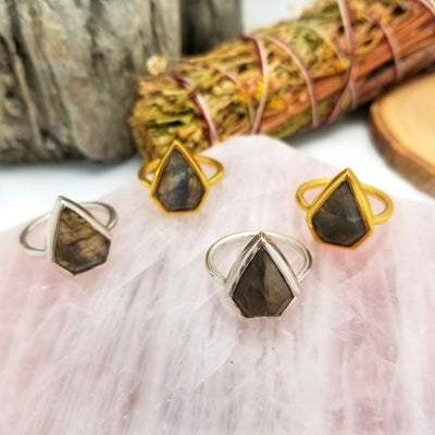 4 labradorite arrowhead rings in gold and silver with decorations is the background