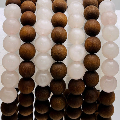 close up of sandalwood bead bracelets with rose quartz on display for details and possible variations