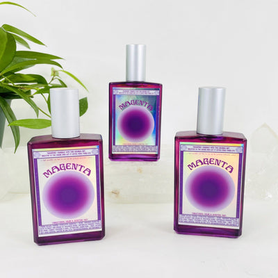 3 bottles of Gemstone Mist - Magenta Vibrational Color with decorations in the background
