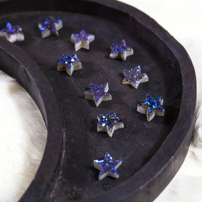 angled shot of titanium blue druzy stars on wooden plate
