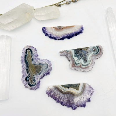 4 Amethyst Stalactite Slices with decorations in the background