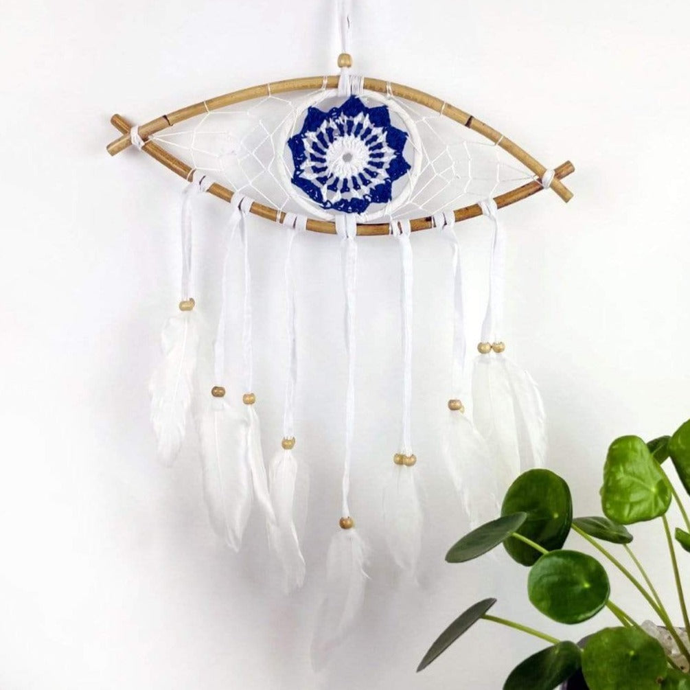 White Dream Catcher with Blue All Seeing Eye Pattern with white ties and white feathers on the end on white background