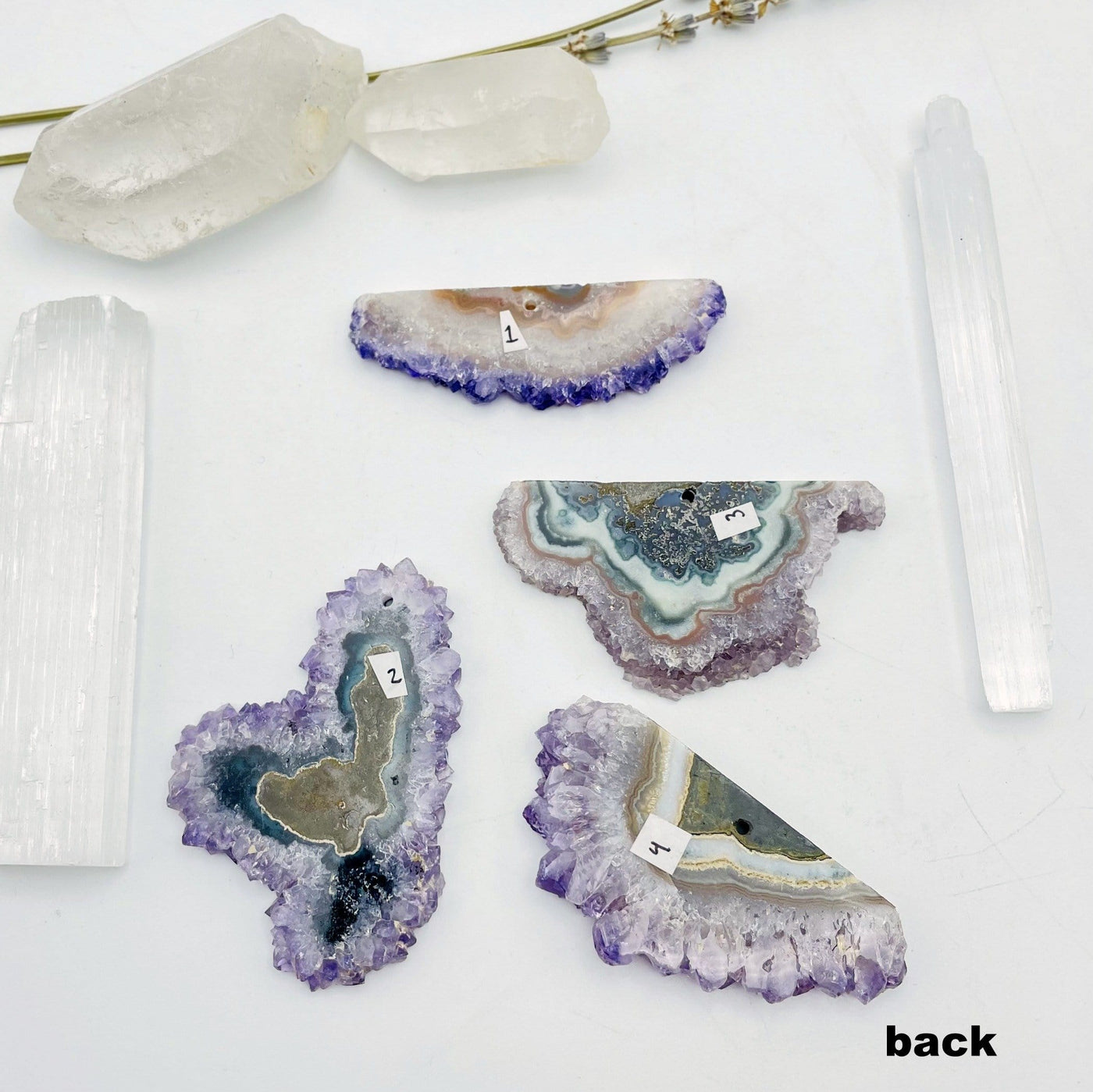 back view of 4 Amethyst Stalactite Slices with decorations in the background