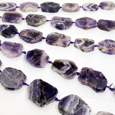 Chevron Amethyst slab beads - Polished Beads--stones slab beads with different tones on table.