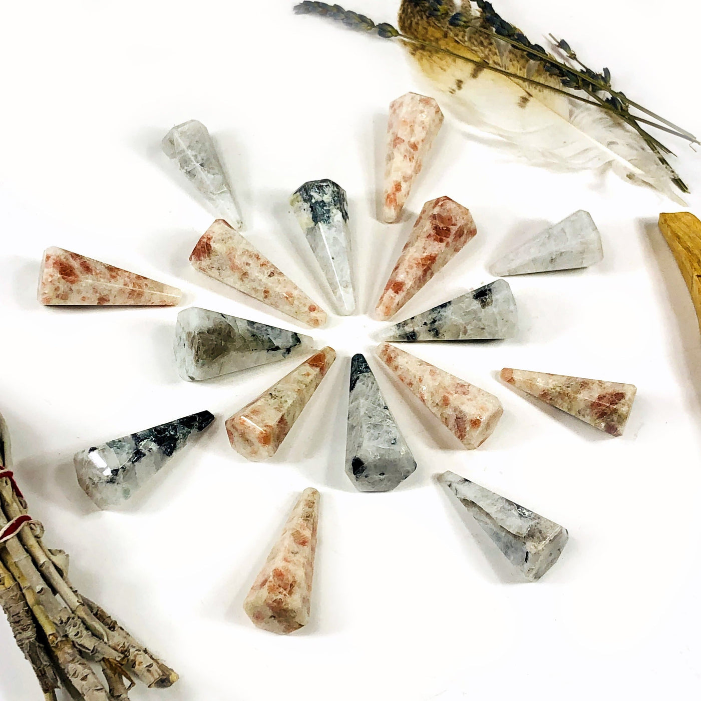 sunstone and moonstone pendulum points on white background with decorations