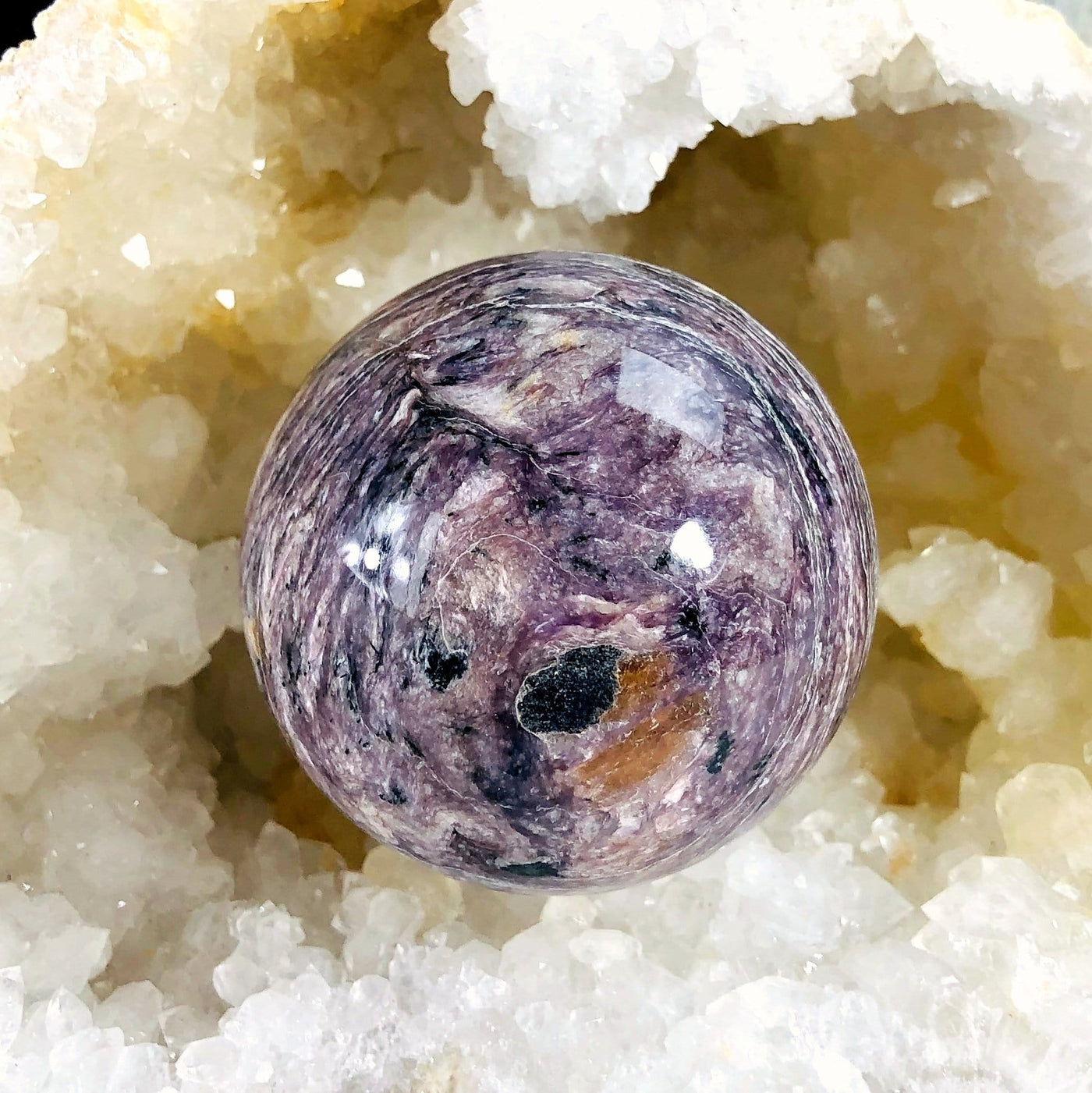 Charoite Polished Sphere with decorations in the background