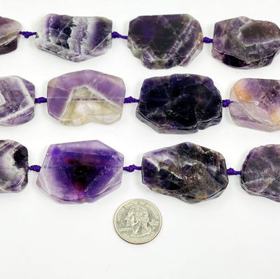 Chevron Amethyst slab beads - Polished Beads--front shot view of different tones of stone and shapes on table.