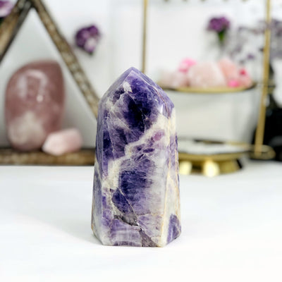 back view of Chevron Amethyst Polished Point with decorations in the background