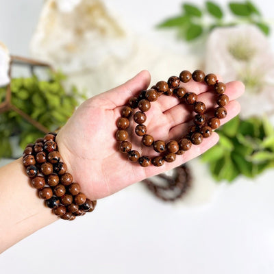8mm Mahogany Obsidian Round Bead Bracelets in hand and on wrist for size reference
