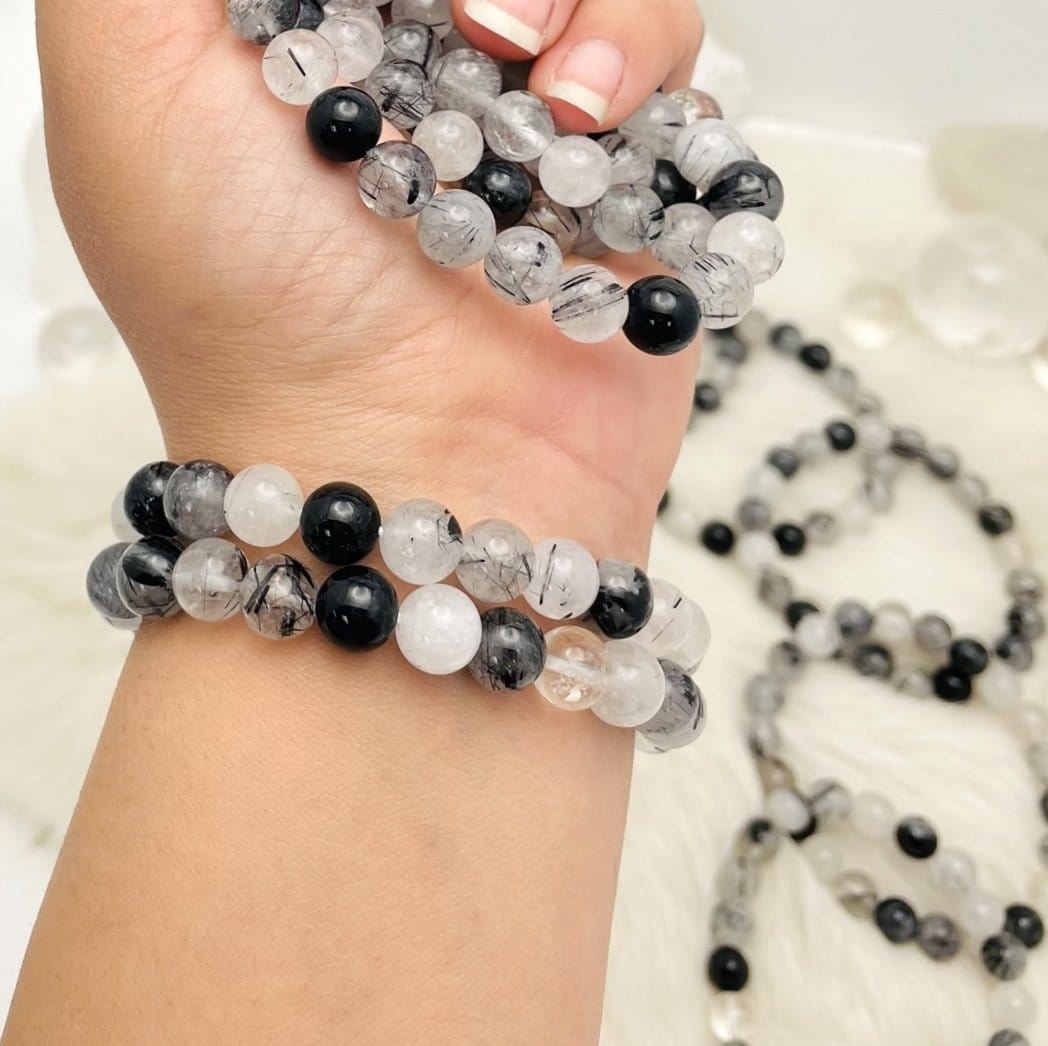 Black Rutilated Round Bead Bracelets  - 2 on an arm and a few in  the hand