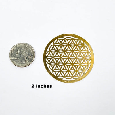 gold toned flower of life grid available in 2" size next to a quarter for size reference