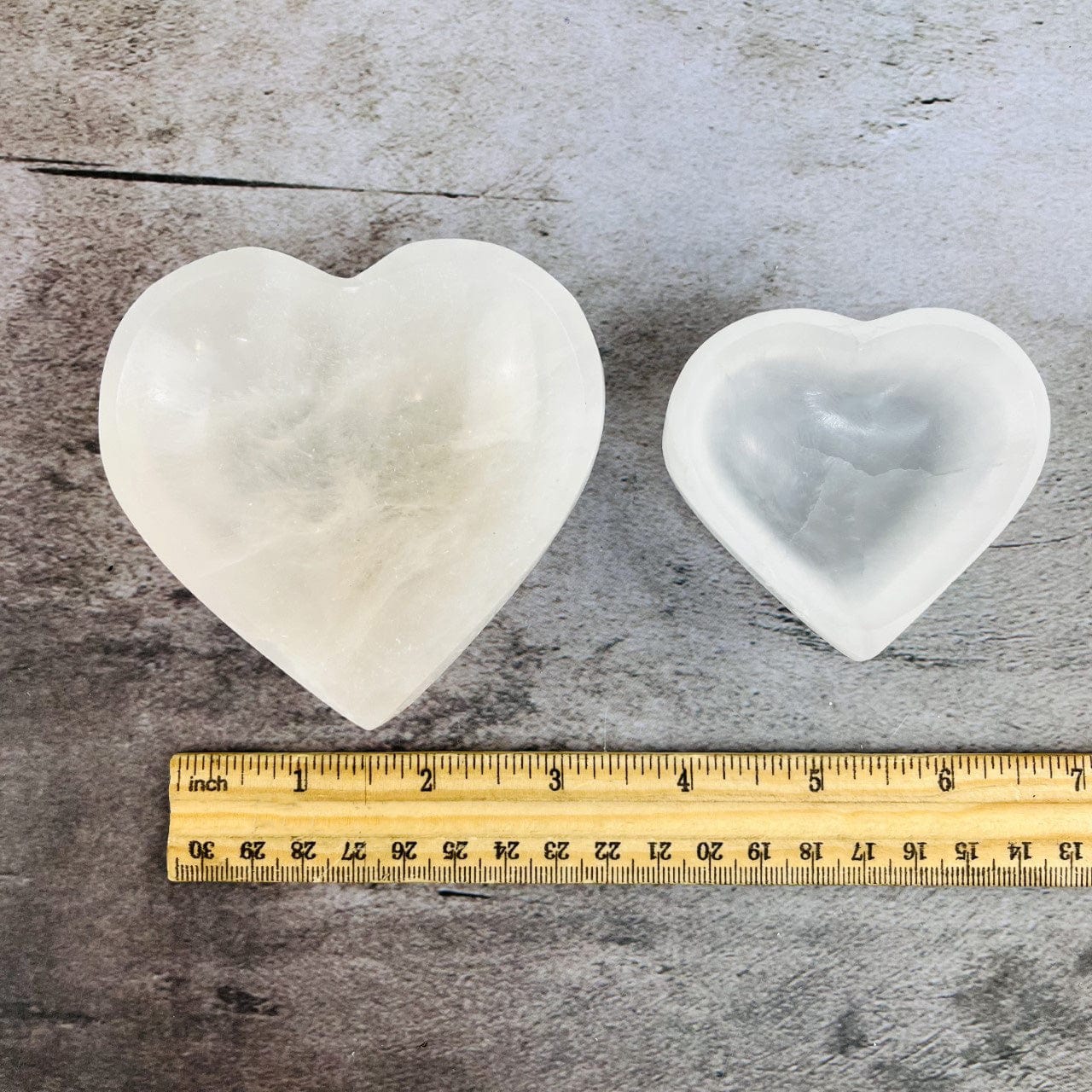 2 sizes of Selenite Heart Bowls next to a ruler for sizing