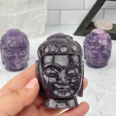 lepidolite carved buddha in hand for size reference 