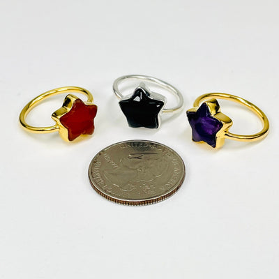 gemstone star rings displayed next to a quarter for size reference 
