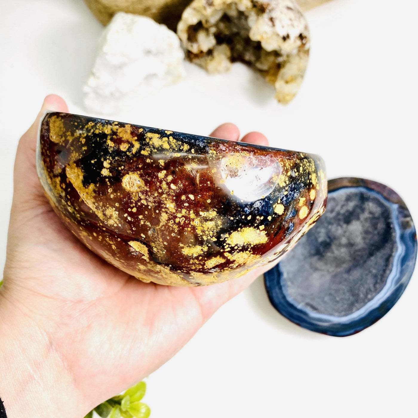 Agate Geode Polished Box held to show the yellow, red, and black colors of the side.