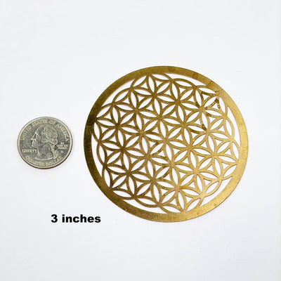 gold toned flower of life grid available in 3" size next to a quarter for size reference