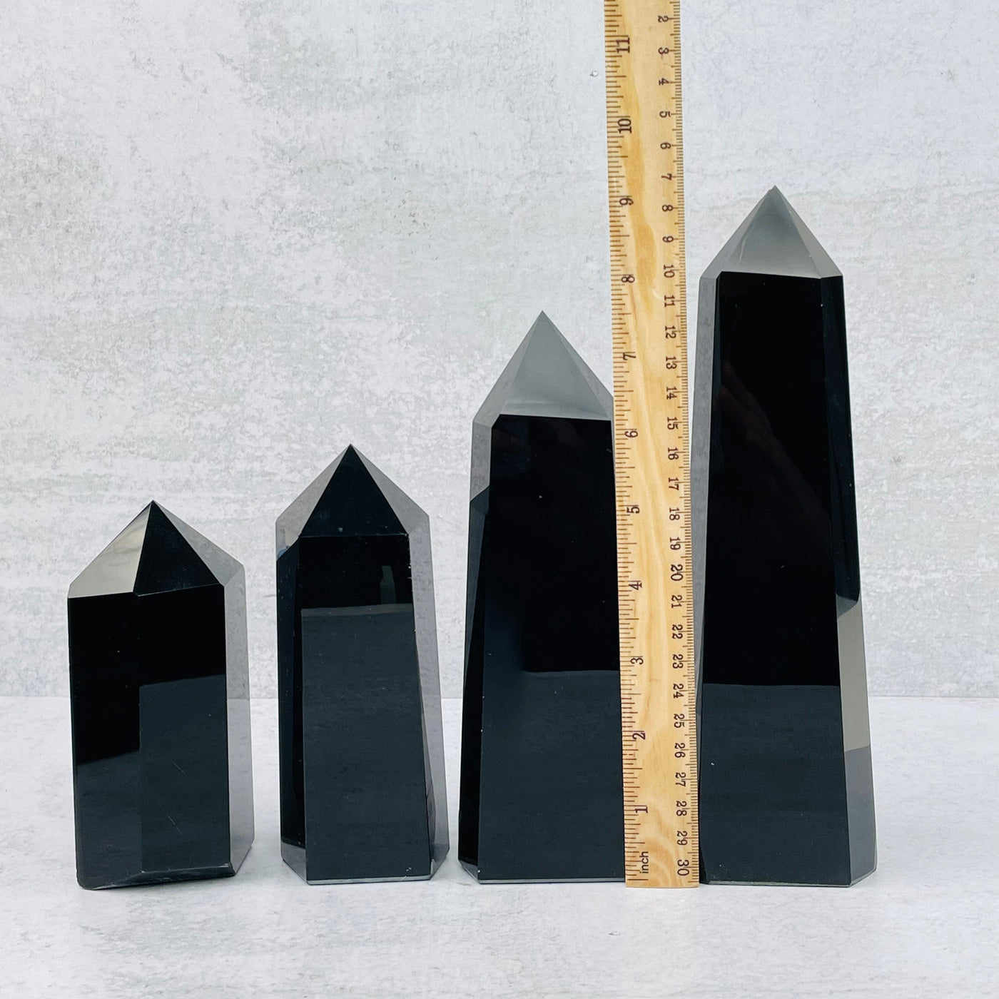 black obsidian towers next to a ruler for size reference 