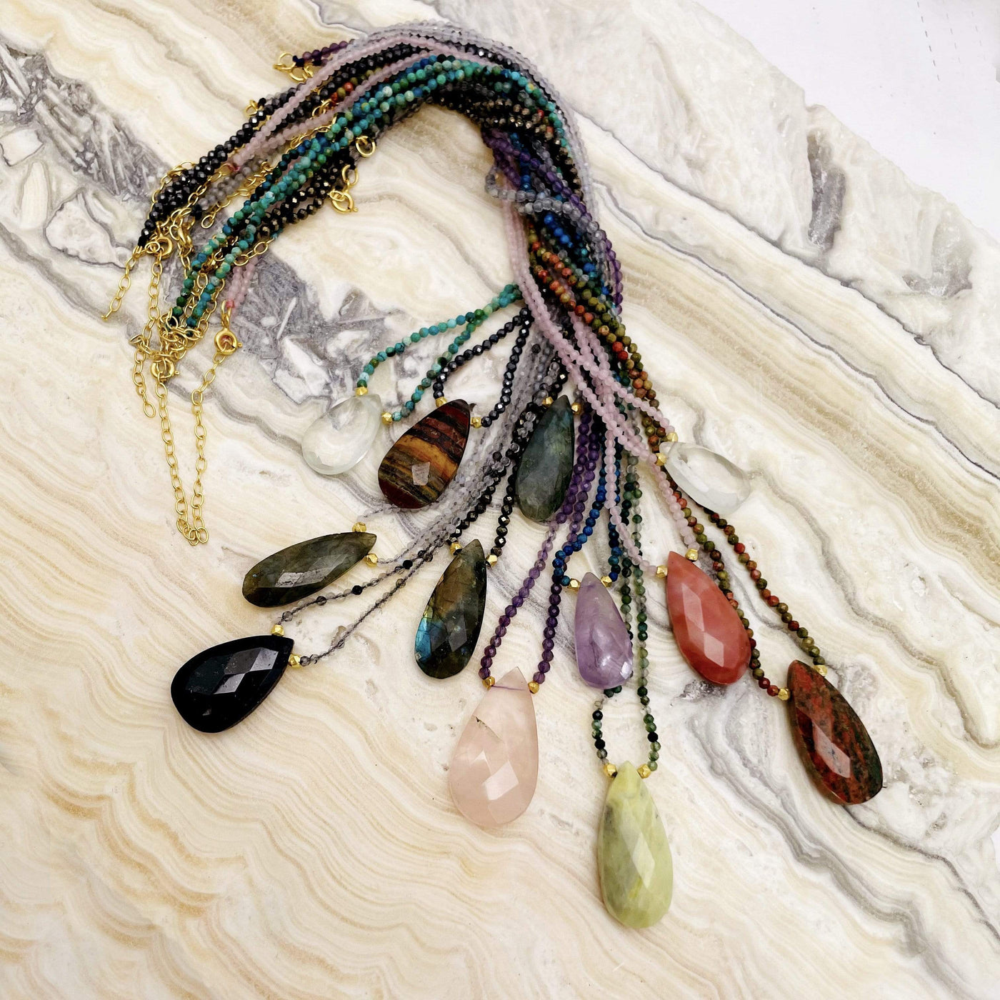 stone teardrop necklaces bundled together on a table