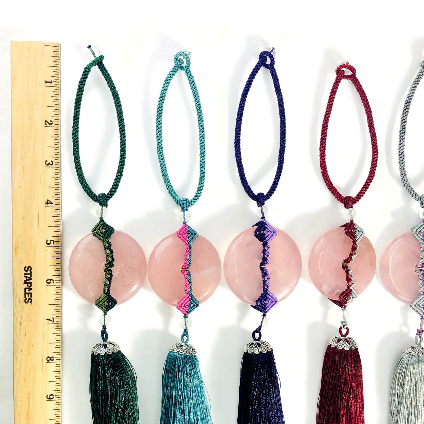 4 Rose Quartz Tassels of different colors next to a ruler for size reference