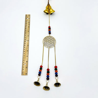 Brass Triple Bell Hanging Flower of Life next to a ruler for size reference