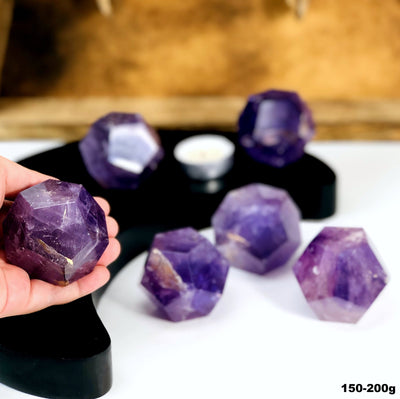 Amethyst Dodecahedron Stones --close shot view of dodecahedron size 150-200 grams in hand for size comparison.