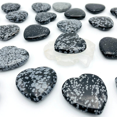 angled view of many snowflake obsidian hearts for thickness