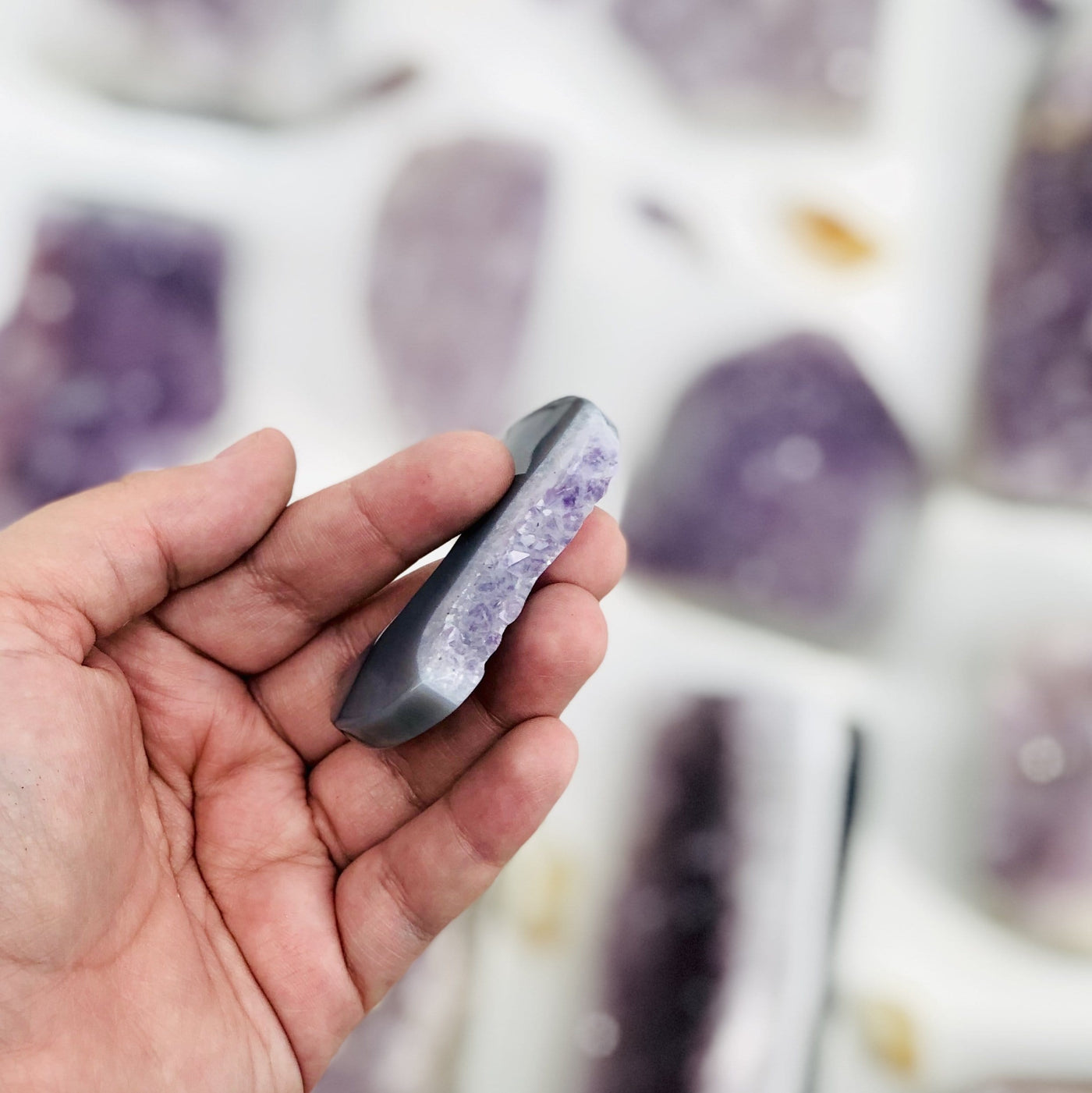 Large Amethyst Half Moon displayed in hand side view to show the druzy edge on the moon