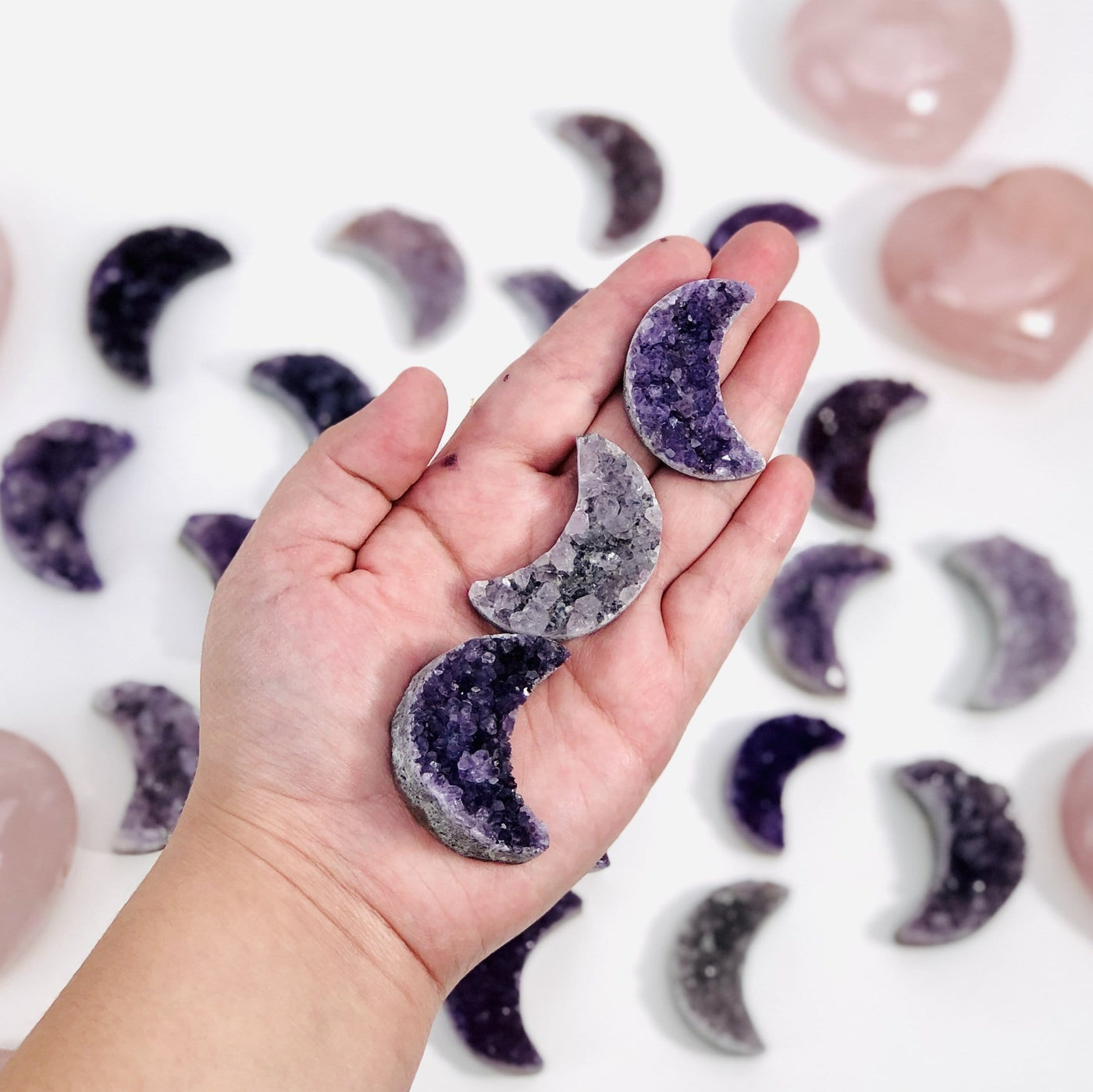 3 amethyst crescent moons in hand to show various purple tones