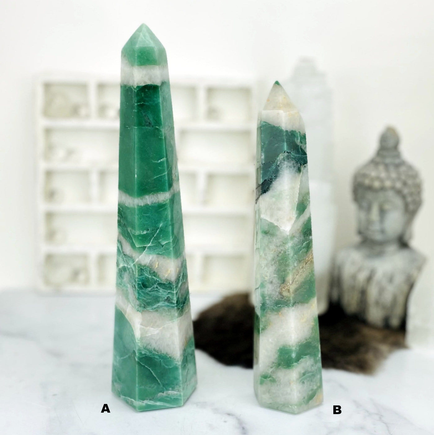2 Green and White Quartz Polished Points with decorations blurred in the background