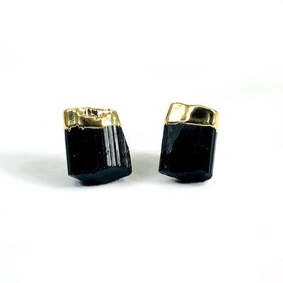 Black tourmaline small stud earrings with gold plated top on a white background.