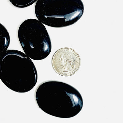 Black Obsidian Worry Stonenext to a quarter for sizing