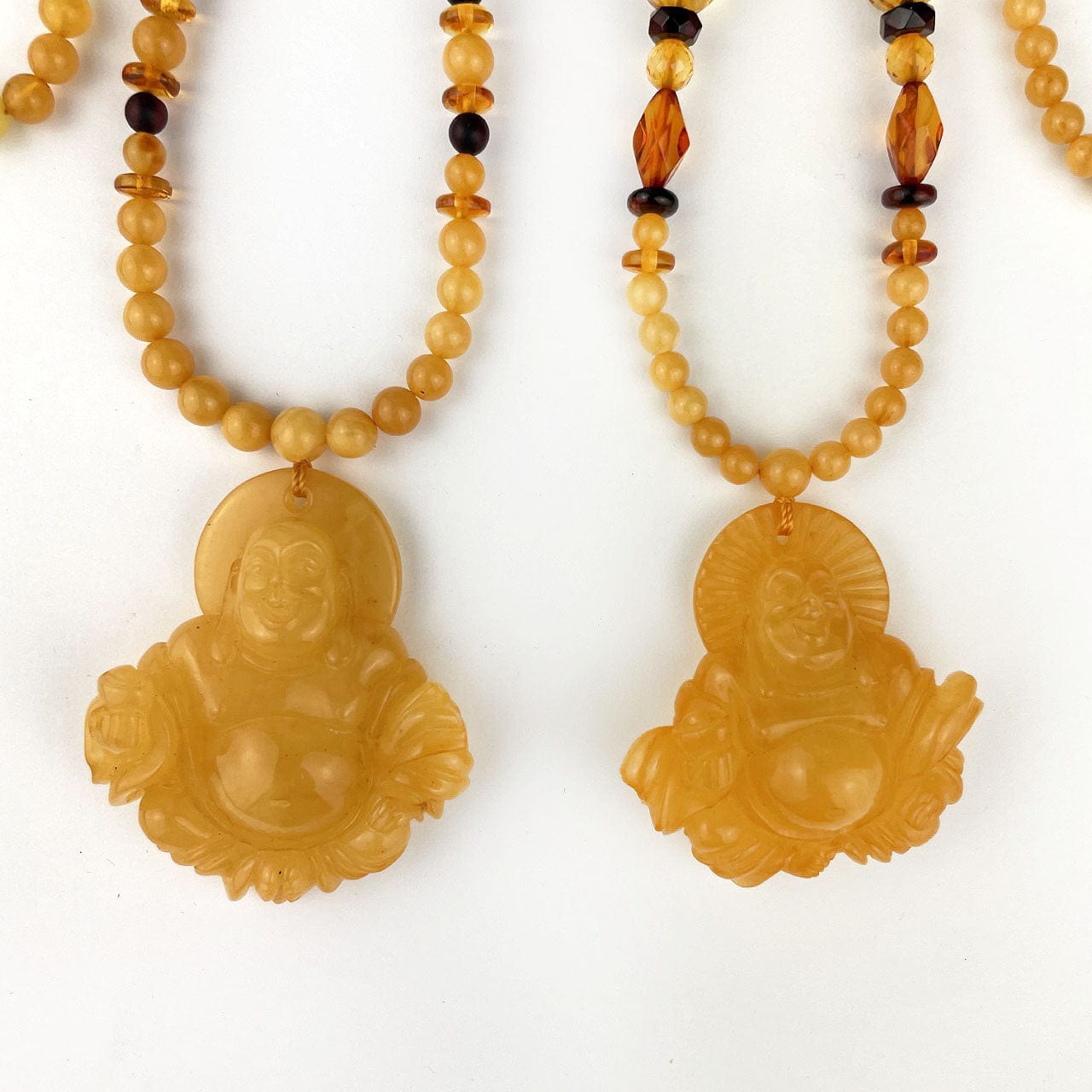 Amber Beaded Necklaces with Carved Buddha Pendants, showing the pendants closer up