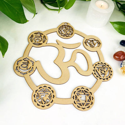 Wood Crystal Grid with seven chakra symbols on edges and OM symbol in the middle on a white background
