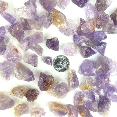 Amethyst Stones spread out with a quarter to show size