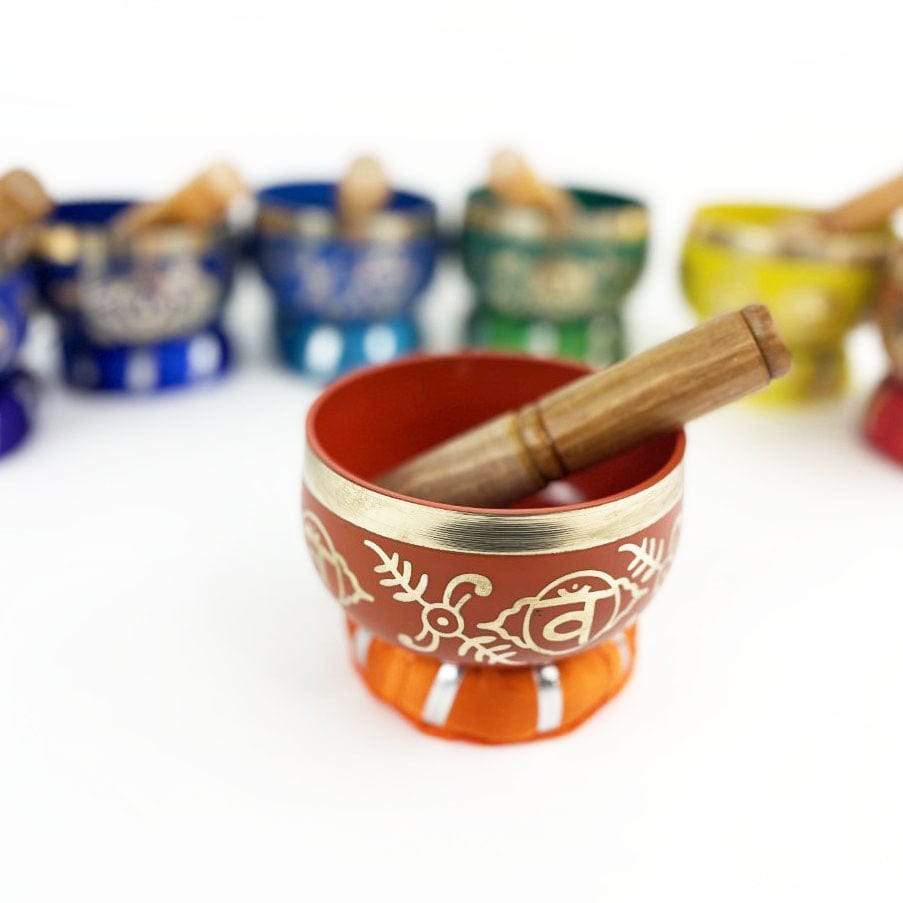 7 Chakra Colorful Singing Bowls, Pillows and Mallets with close up on orange