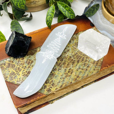 angled view of selenite knife with unalome engraving