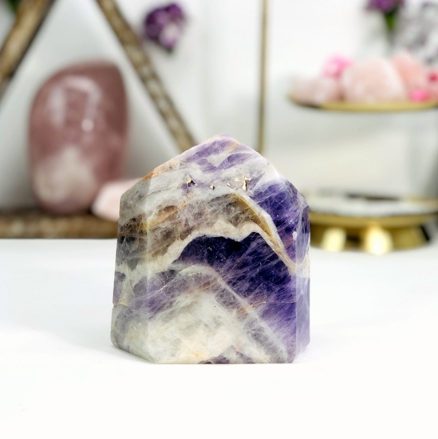Chevron Amethyst Polished Point with decorations in the background