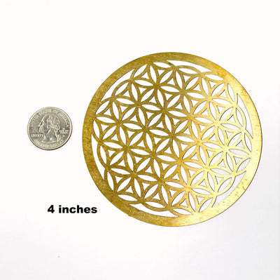 gold toned flower of life grid available in 4" size next to a quarter for size reference