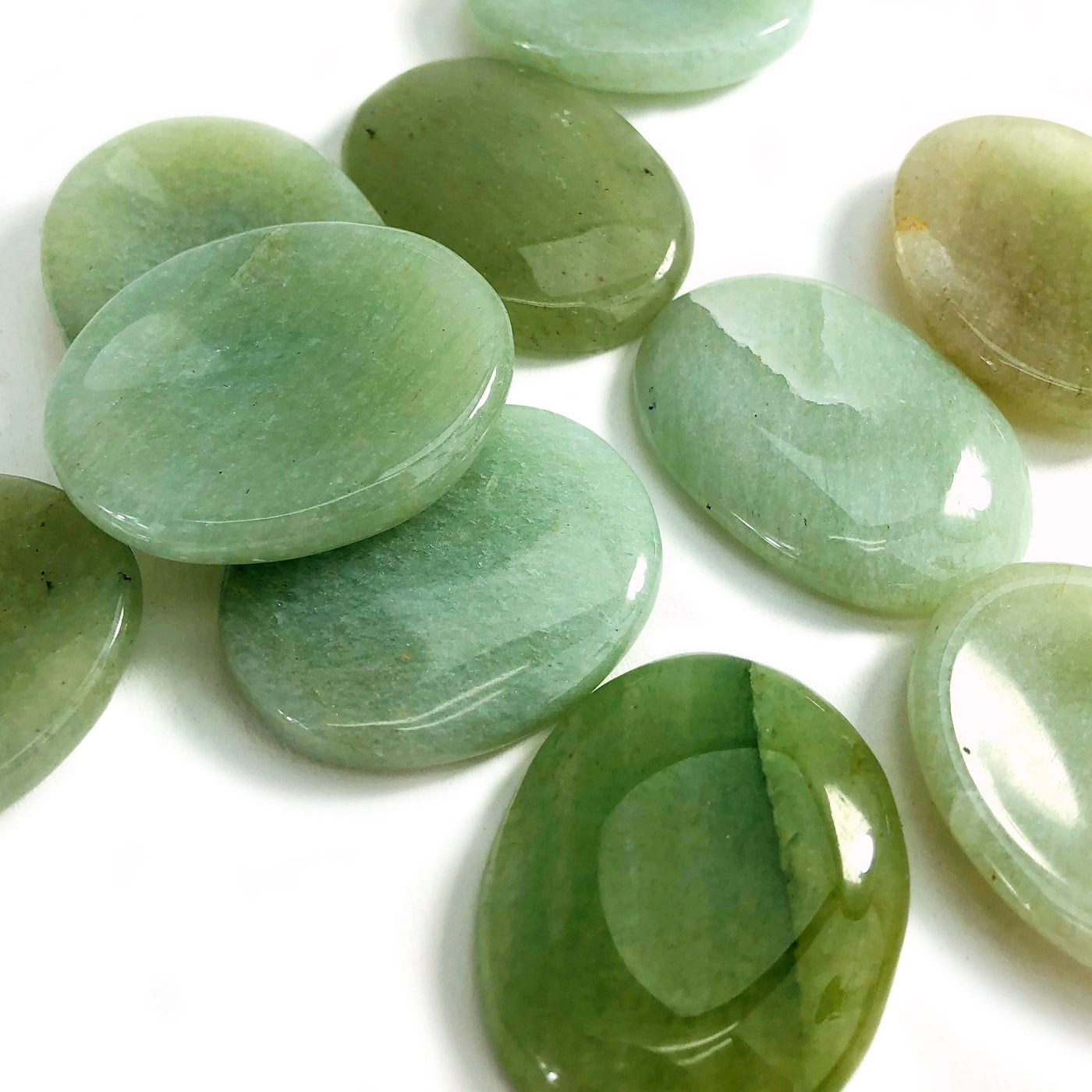 Green Aventurine Worry Stones spread out on white backgound