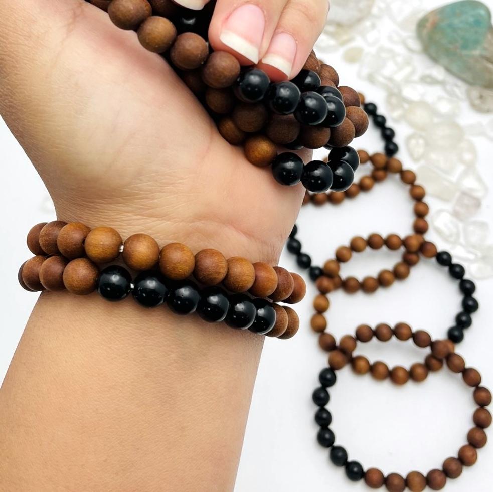 sandalwood bead bracelets with black obsidian on wrist and on display for size reference