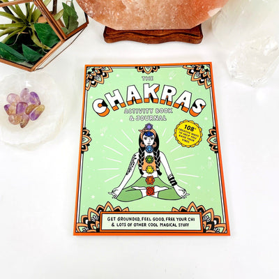 The Chakras Activity Book & Journal laying flat on a table 