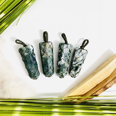 4 moss agate netted points with decorations in the background