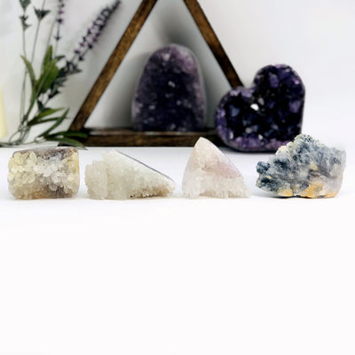 4 Amethyst Flower Crystal Clusters with decorations in the background