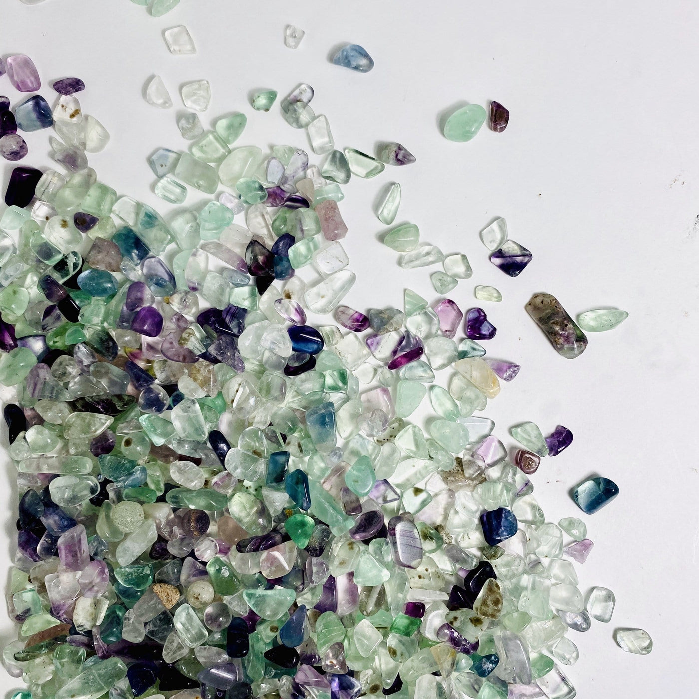 fluorite chips in green purple and blue on a white background